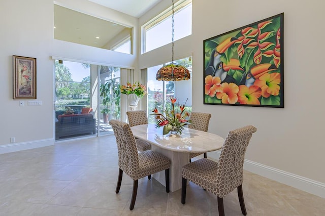 dining space featuring light tile patterned flooring, plenty of natural light, and baseboards