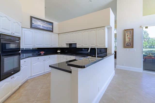 kitchen with dobule oven black, backsplash, dark countertops, white cabinetry, and light tile patterned flooring