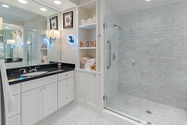 bathroom with vanity, a shower stall, a walk in closet, and ornamental molding