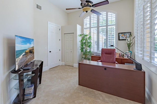 office space featuring light tile patterned floors, baseboards, visible vents, and ceiling fan