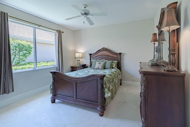 bedroom with a ceiling fan, baseboards, and light carpet