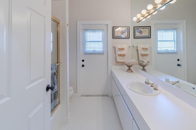 full bathroom featuring tile patterned floors, toilet, vanity, and a shower with shower door