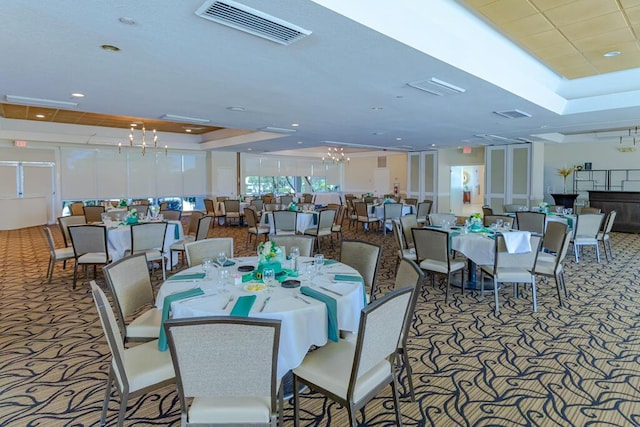 carpeted dining space with a tray ceiling, visible vents, and recessed lighting