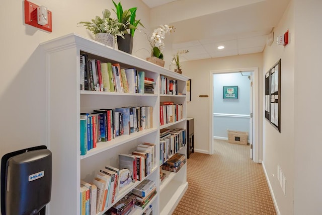 corridor with recessed lighting, a paneled ceiling, baseboards, and carpet floors