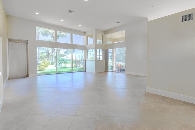 2488 SW Longwood Dr, Palm City, FL 34990 - spare room featuring light tile patterned floors, baseboards, a high ceiling, and visible vents
