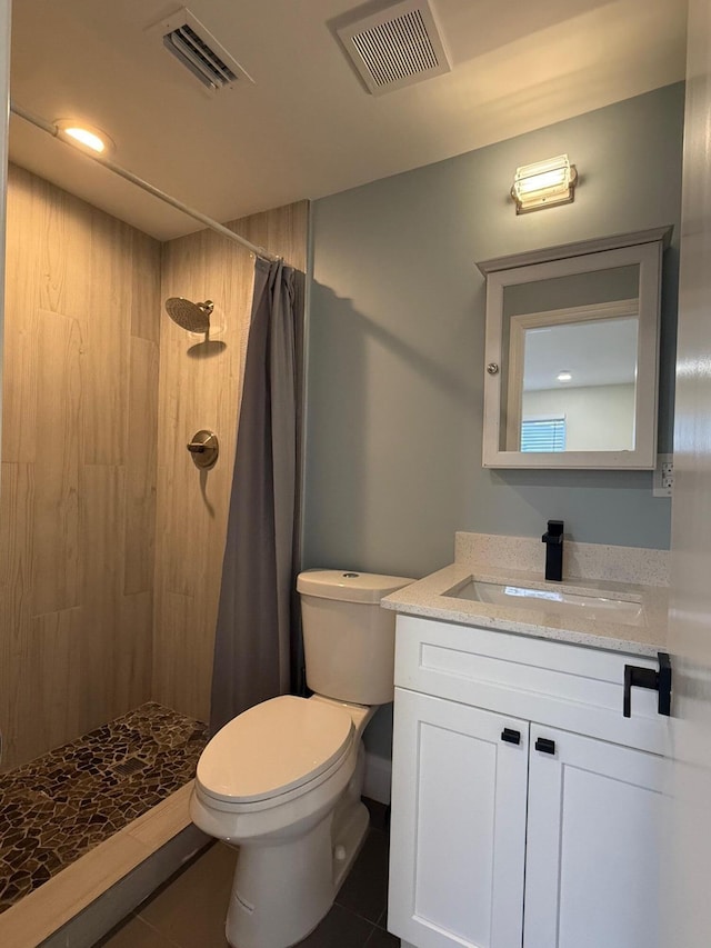 bathroom featuring tile patterned floors, visible vents, tiled shower, and toilet