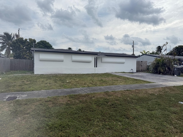 view of front facade with a front lawn and fence