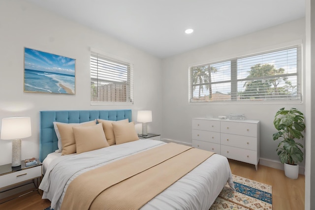 bedroom featuring wood finished floors, baseboards, and recessed lighting