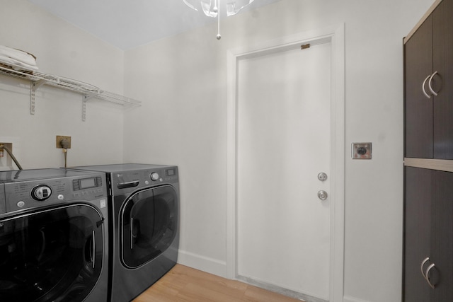 laundry room with washer and clothes dryer, light wood finished floors, and baseboards