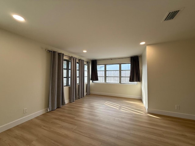 spare room featuring visible vents, recessed lighting, baseboards, and light wood-style floors