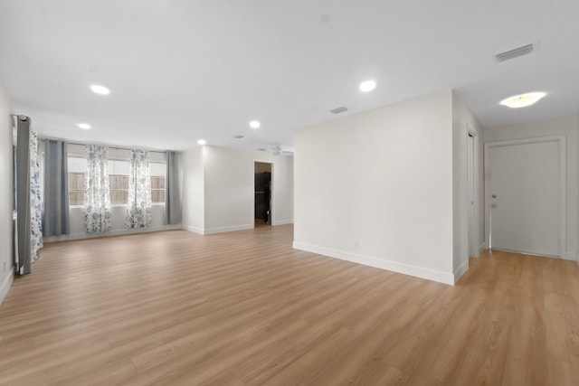 empty room with light wood-style flooring, recessed lighting, and baseboards