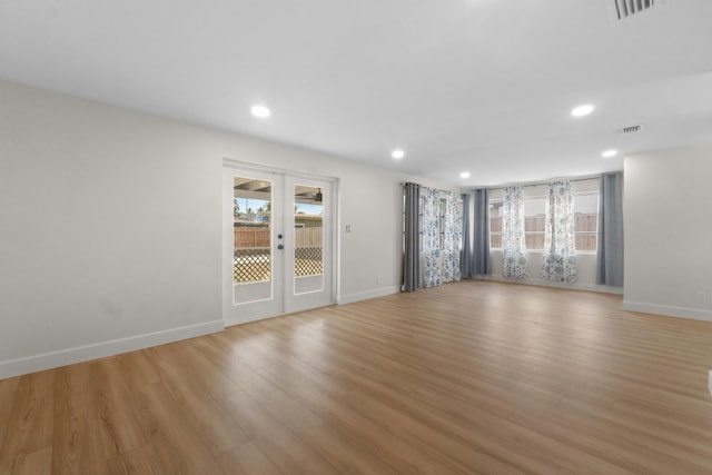 empty room featuring healthy amount of natural light, light wood-type flooring, baseboards, and recessed lighting