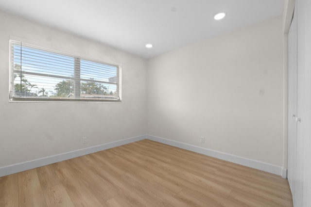 spare room featuring light wood-style flooring, baseboards, and recessed lighting