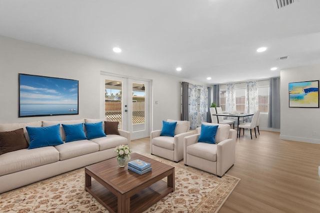 living room featuring plenty of natural light, light wood finished floors, recessed lighting, and baseboards