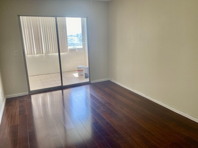 unfurnished room with baseboards and dark wood-style flooring