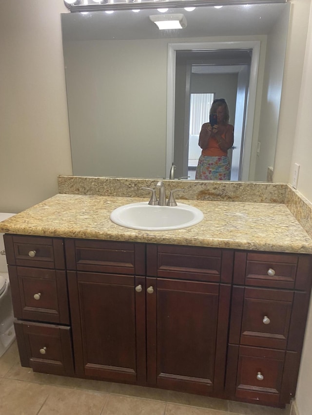 bathroom featuring vanity, toilet, and tile patterned flooring