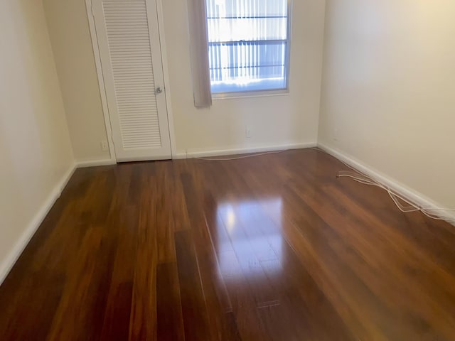 empty room featuring baseboards and wood finished floors