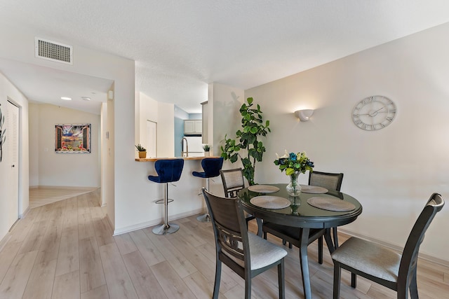 dining space with visible vents, baseboards, and light wood-style floors