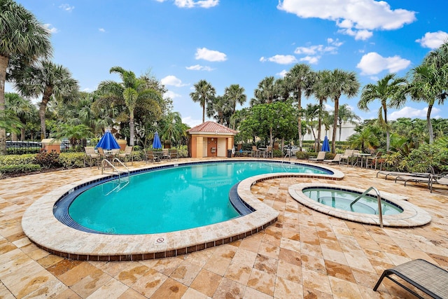 community pool with a patio area and a community hot tub