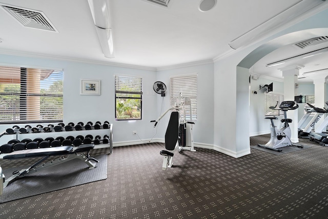 gym with visible vents, arched walkways, baseboards, and ornamental molding