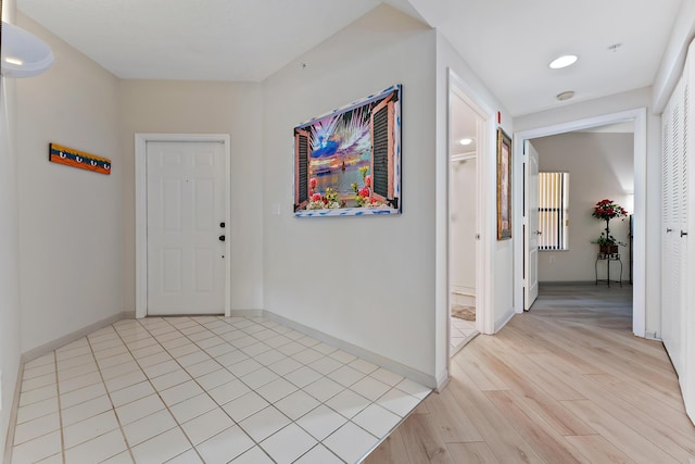 foyer entrance featuring light wood-style flooring and baseboards