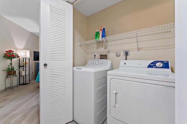 laundry area featuring laundry area, washing machine and dryer, and light wood-type flooring