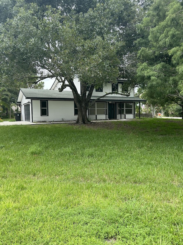 view of yard featuring a garage and a sunroom