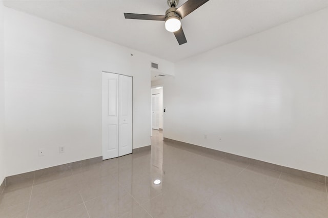 unfurnished bedroom featuring a closet, visible vents, tile patterned floors, and a ceiling fan