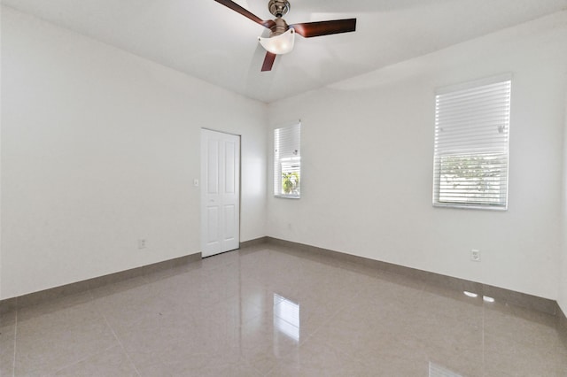 empty room featuring baseboards and ceiling fan