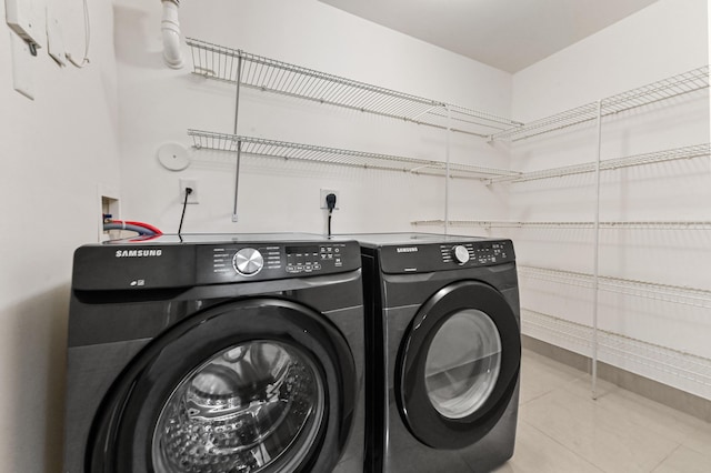 clothes washing area with laundry area, independent washer and dryer, and tile patterned floors