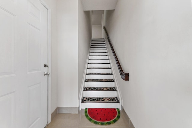 stairs featuring tile patterned floors and baseboards