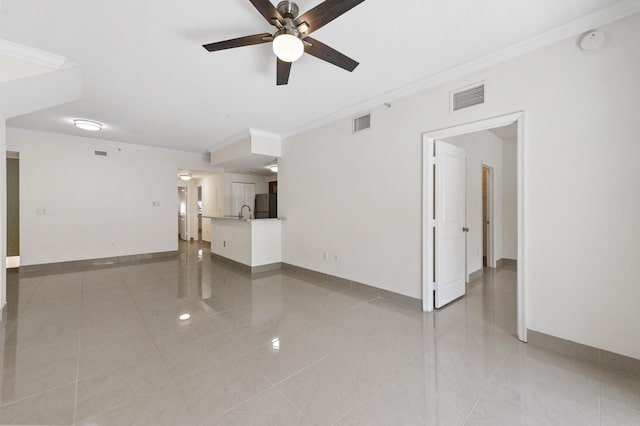 unfurnished living room with visible vents, a ceiling fan, baseboards, and ornamental molding