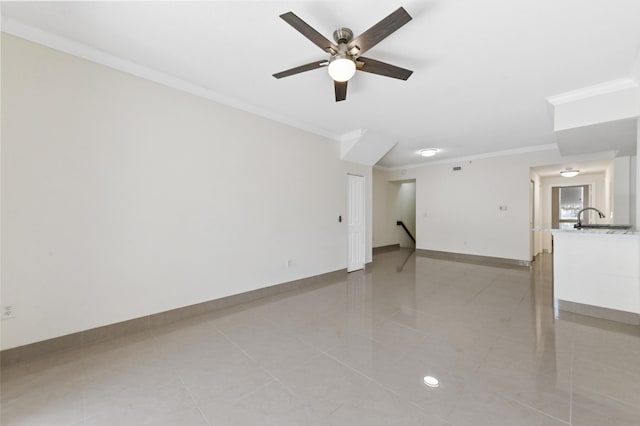 empty room featuring a sink, baseboards, ornamental molding, and ceiling fan