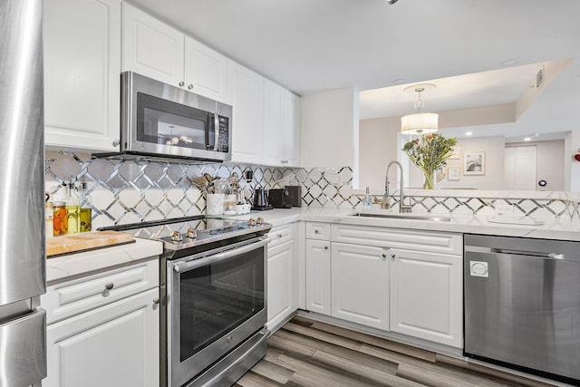 kitchen with a sink, appliances with stainless steel finishes, and white cabinetry