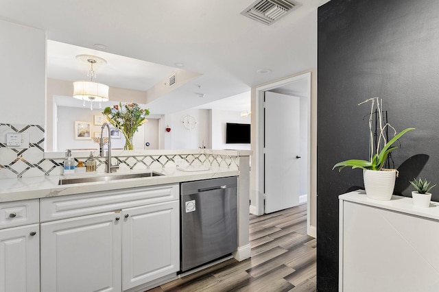 kitchen featuring decorative backsplash, a sink, visible vents, and stainless steel dishwasher