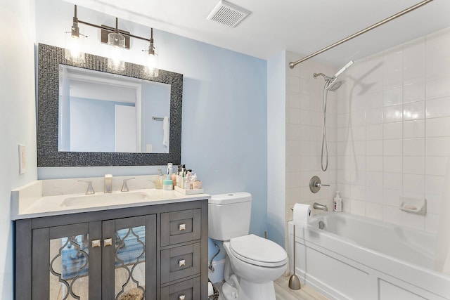 bathroom featuring vanity, toilet, visible vents, and shower / bath combination