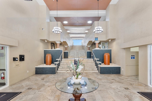 interior space featuring stairs, a towering ceiling, and a chandelier