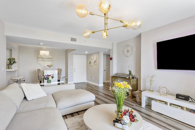 living room with wood finished floors, visible vents, and baseboards