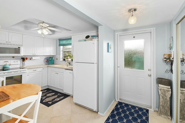 kitchen featuring a sink, white cabinetry, white appliances, light countertops, and light tile patterned floors