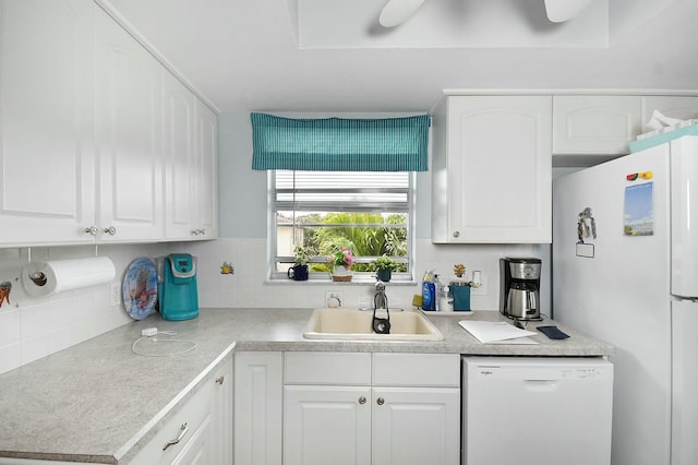 kitchen with white cabinetry, white appliances, backsplash, and a sink