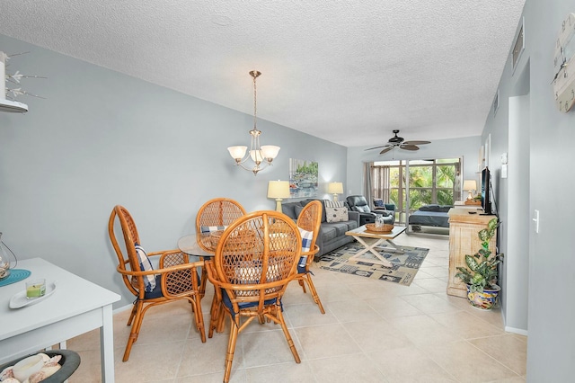 dining area with light tile patterned floors, ceiling fan with notable chandelier, baseboards, and a textured ceiling