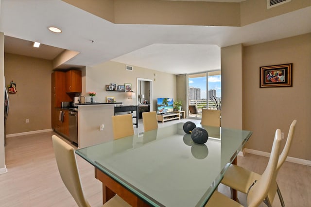 dining room with visible vents, baseboards, and light wood-style floors