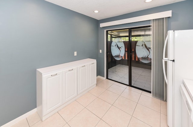 interior space featuring recessed lighting, baseboards, and light tile patterned floors