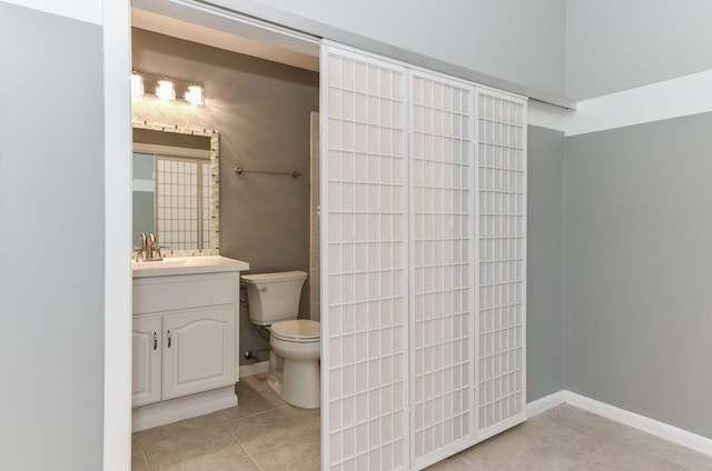 bathroom with vanity, tile patterned floors, toilet, and baseboards