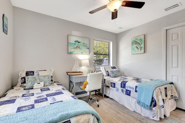 bedroom featuring ceiling fan, visible vents, and wood finished floors