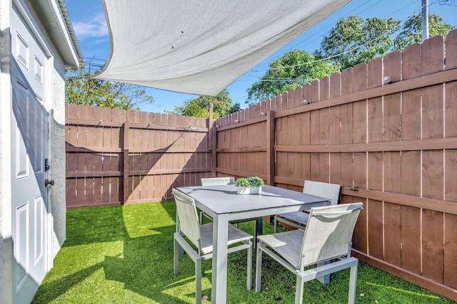 view of yard featuring outdoor dining area and fence