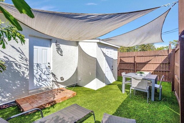 view of yard with outdoor dining area and fence