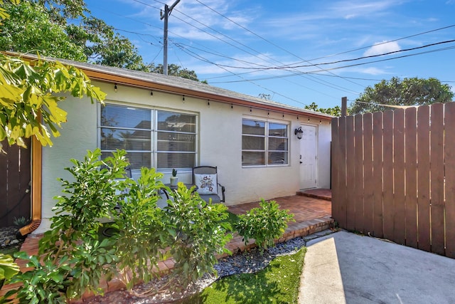 exterior space featuring a patio, fence, and stucco siding