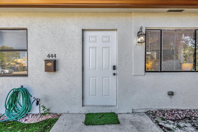 property entrance featuring stucco siding