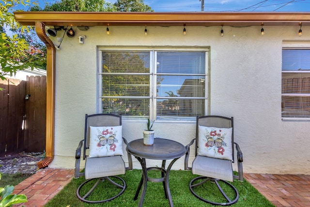 back of property featuring stucco siding and fence